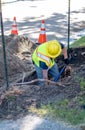 Electrical worker digs to reach a buried cable