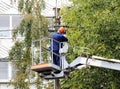 Electrical worker repairing the wires on the pole with the help of the lift car.