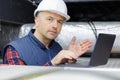 Electrical worker testing wire with laptop Royalty Free Stock Photo