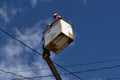 Electrical Workers On Telehandler With Bucket installing High tension wires on tall concrete post. Underside view low angle