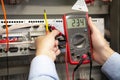 Electrician adjusts electrical control panel Royalty Free Stock Photo