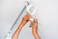 Electrician african man worker installing a ceiling LED spotlight