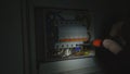 Electrician assembles electrical panel in dark by light of flashlight. Close up of a man hands tightening a screw with a Royalty Free Stock Photo