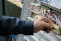 Electrician assembling industrial HVAC control panel in workshop. Close-up photo.