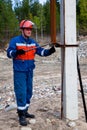 Electrician in blue overalls makes switching