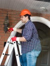 Electrician changing bulb in outdoor lamp on house wall Royalty Free Stock Photo