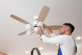 Electrician changing light bulb in ceiling fan indoors Royalty Free Stock Photo