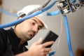 Electrician checking phone installing electrical system Royalty Free Stock Photo