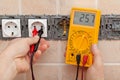 Electrician checking voltage in a partially installed electrical