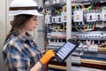 Electrician checks switchgear via tablet interface. Real time control. Royalty Free Stock Photo