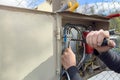 An electrician connects wires in a switchboard outdoors. The hands of an electrician close-up inserts the wire into the Royalty Free Stock Photo