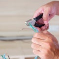 Electrician cuts electrical wires with pliers, Wiring cables installation for socket plug. Fixing, Renovation, Repair, service and Royalty Free Stock Photo