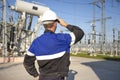 Electrician engineer on power electric station look at industrial equipment. Technician in helmet on electro substation Royalty Free Stock Photo