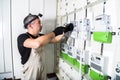 Electrician engineer works with screwdriver on fuse switch box