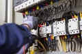 Electrician engineer tests electrical installations and wires on relay protection system. Royalty Free Stock Photo