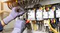 Electrician engineer tests electrical installations and wires on relay protection system. Adjustment of scheme of automation and Royalty Free Stock Photo