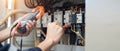 Electrician engineer work tester measuring voltage and current of power electric line in electrical cabinet control , concept chec Royalty Free Stock Photo
