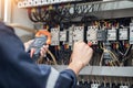 Electrician engineer work tester measuring voltage and current of power electric line in electrical cabinet control , concept chec Royalty Free Stock Photo