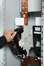 Electrician engineer work tester measuring voltage and current of power electric line in electical cabinet control.and