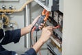 Electrician engineer work tester measuring voltage and current of power electric line in electrical cabinet control , concept chec Royalty Free Stock Photo