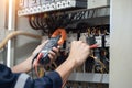 Electrician engineer work tester measuring voltage and current of power electric line in electrical cabinet control , concept chec Royalty Free Stock Photo
