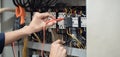 Electrician engineer work tester measuring voltage and current of power electric line in electrical cabinet control , concept chec Royalty Free Stock Photo