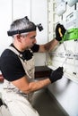Electrician engineer works with screwdriver on fuse switch box close up Royalty Free Stock Photo