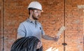 A worker at a construction site holds an electrical cable Royalty Free Stock Photo