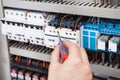 Electrician examining fusebox with screwdriver Royalty Free Stock Photo