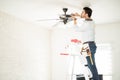 Electrician fixing a ceiling fan Royalty Free Stock Photo