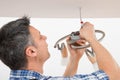 Electrician fixing light on ceiling Royalty Free Stock Photo