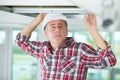 Electrician fixing neon on ceiling Royalty Free Stock Photo