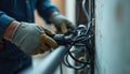 Electrician gloved hands carefully run electrical cables through conduit. Construction work emphasizes precision, safety in Royalty Free Stock Photo