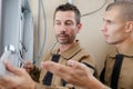 Electrician guiding apprentice in connecting wires