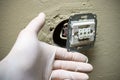 Electrician hands in gloves installing light switch in wall Royalty Free Stock Photo