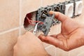 Electrician hands installing wires into a wall fixture Royalty Free Stock Photo