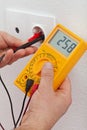 Electrician hands measuring voltage in electrical outlet Royalty Free Stock Photo