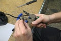 Electrician hands stripping wire connections with stripper, pliers and other tools on a worktable Royalty Free Stock Photo