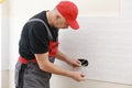 Electrician hands tighten electrical wires in wall fixture or socket using a screw driver - closeup. Installing electrical outlet Royalty Free Stock Photo