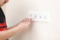 Electrician hands tighten electrical wires in wall fixture or socket using a screw driver - closeup. Installing Royalty Free Stock Photo