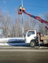 An electrician at height on an aerial platform repairs high-voltage line. Royalty Free Stock Photo