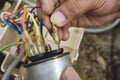 An electrician hook up wires to the terminals of a CBB65A-1 capacitor, part of a window type air conditioner control panel Royalty Free Stock Photo