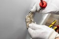 An electrician inserts a double grounded electrical socket into an electrical box in the room wall. Royalty Free Stock Photo