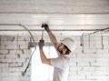 Electrician installer with a tool in his hands, working with cable on the construction site Royalty Free Stock Photo