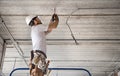 Electrician installer with a tool in his hands, working with cable on the construction site Royalty Free Stock Photo