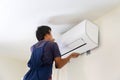 Electrician installing air conditioner unit, Technician man installing an air conditioning in a client house, Repairman fixing air Royalty Free Stock Photo