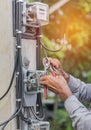 Electrician installing electric meter for measuring power into electric line distribution fuseboard