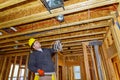 Electrician installing electrical cable wire in unfinished room Royalty Free Stock Photo