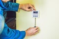 Electrician installing an electrical thermostat in a new house Royalty Free Stock Photo