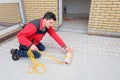 Electrician installing heating electrical cable on concrete floor. Man remove adgesive tape Royalty Free Stock Photo